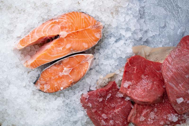 Close-up of high-quality frozen meat cubes, organ meats, and vegetables in vacuum-sealed packaging